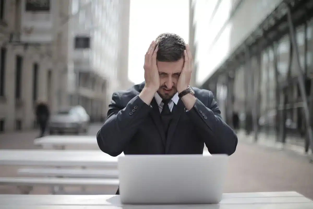 Personne en détresse tenant sa tête, exprimant le malaise et la tension liés aux vertiges causés par le stress