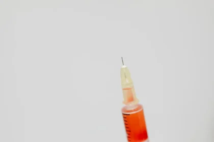 Mains anonymes tenant une seringue et un flacon de vaccin à un comptoir de pharmacie