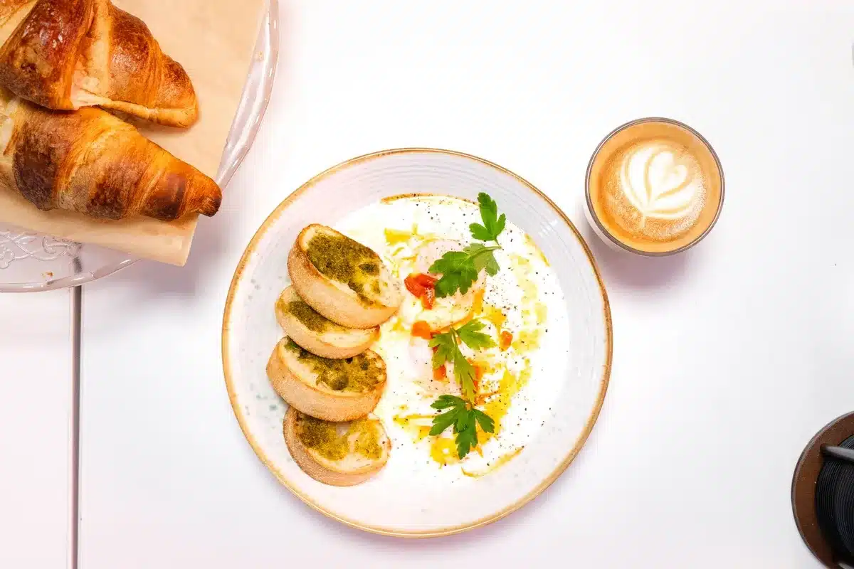 Œufs au pesto servis dans une assiette pour le petit-déjeuner équilibré