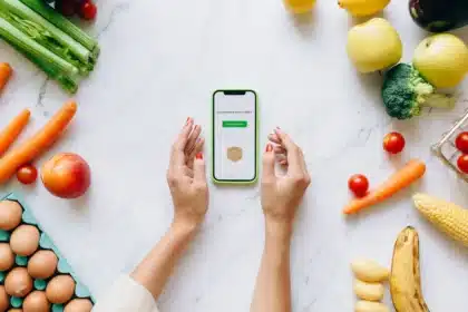 Écran de téléphone affichant des vidéos de tendances culinaires, entouré d'ingrédients frais sur une table