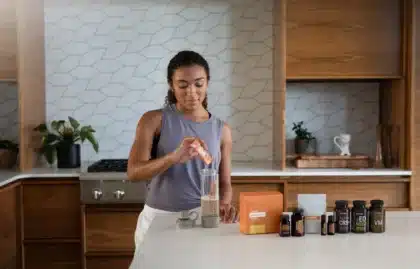 Verre d'eau avec poudre de psyllium et gélules sur une surface neutre