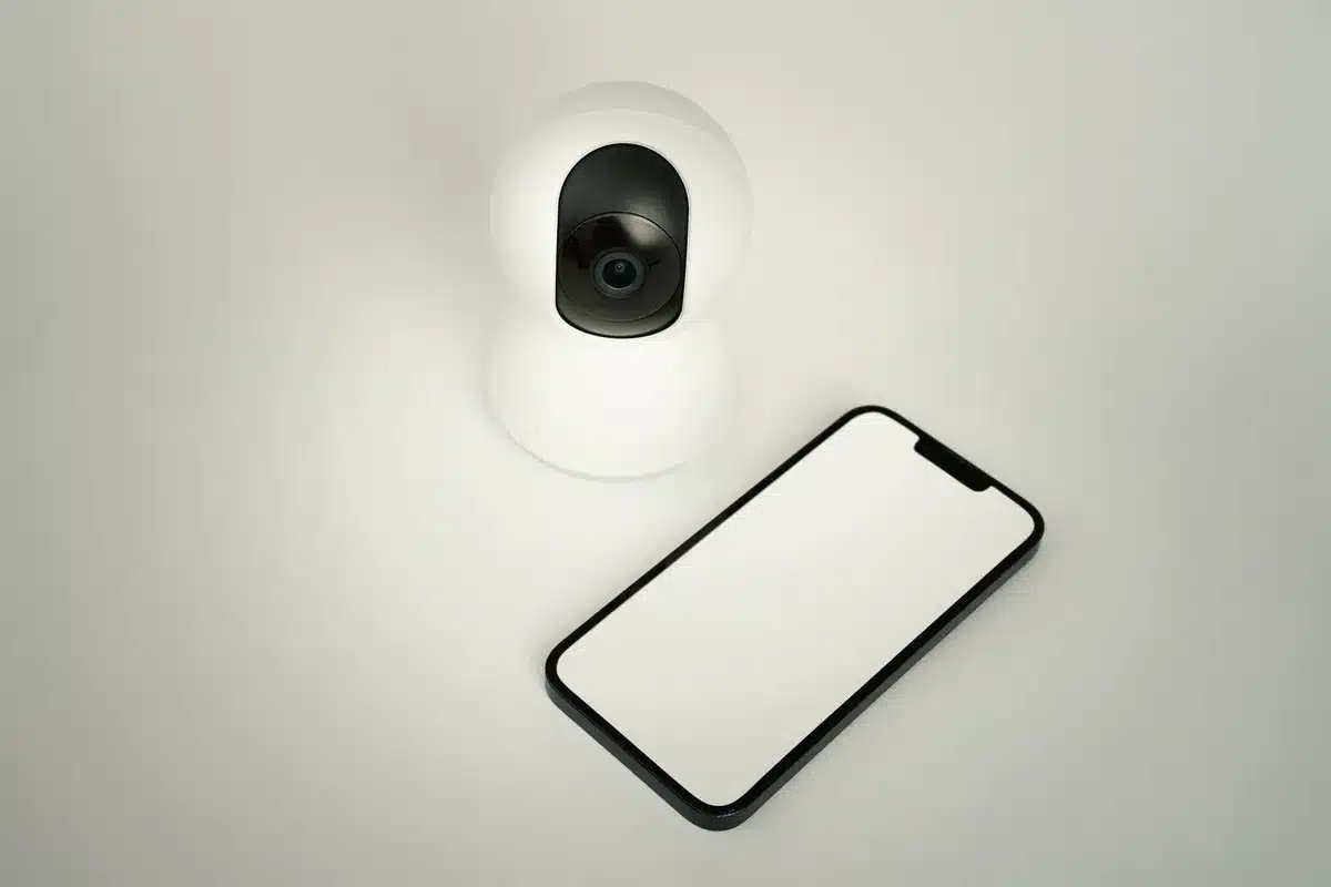 Mains tenant un t&eacute;l&eacute;phone, symbole de contr&ocirc;le et de surveillance num&eacute;rique.