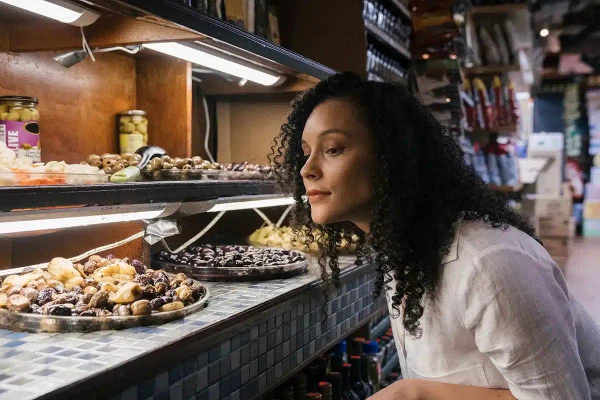 Femme choisissant une bouteille d'huile d'olive en magasin