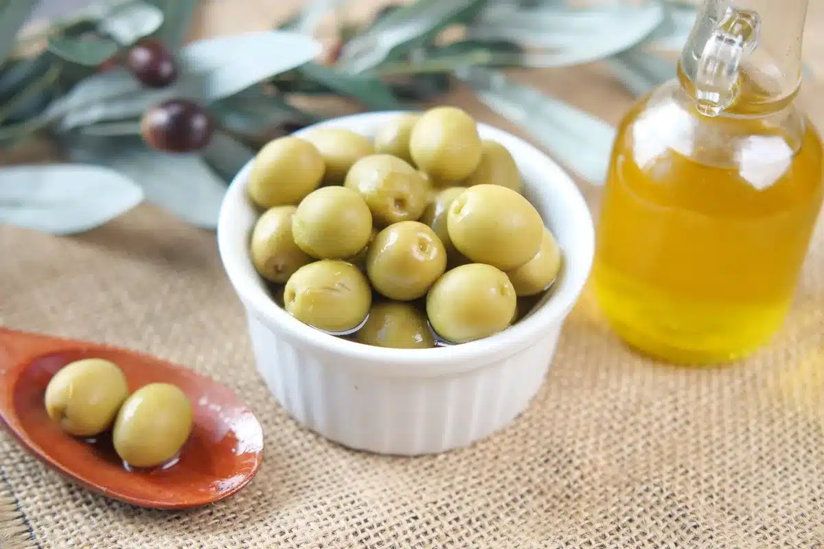 Mains inspectant attentivement une bouteille d'huile d'olive pour vérifier l'étiquetage et la qualité de l'emballage