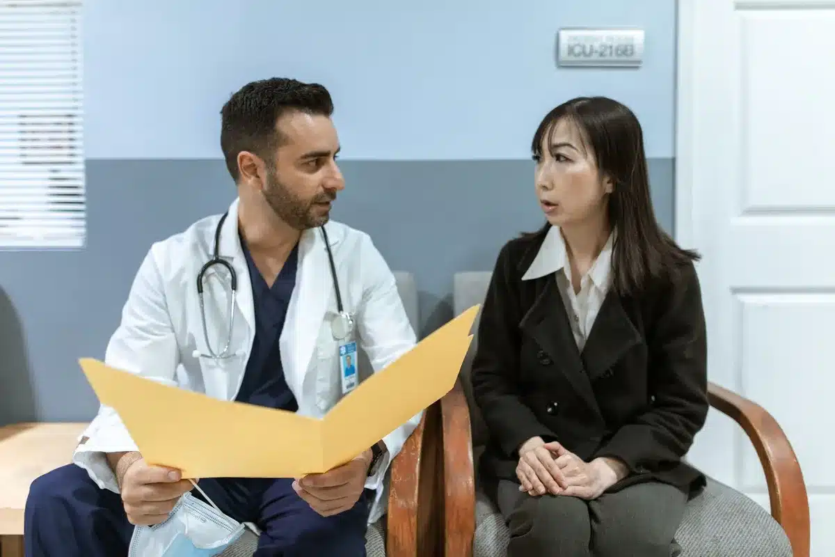 Consultation m&eacute;dicale entre un patient et un praticien discutant des effets secondaires d'un traitement
