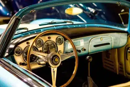 Mains sur le volant et pied près des pédales dans une voiture, illustrant les défis de coordination motrice.