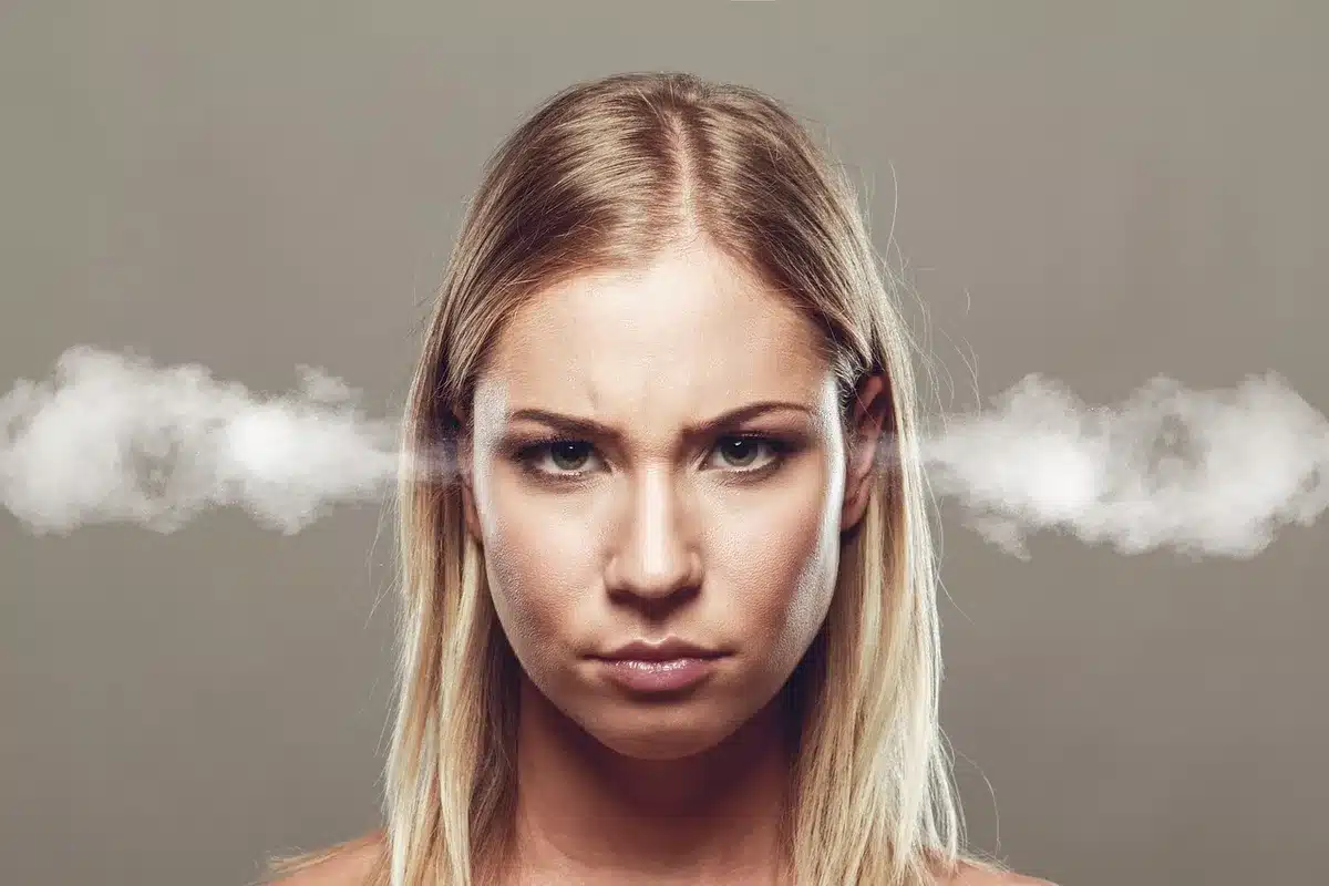Personne assise à un bureau la journée, montrant fatigue et stress