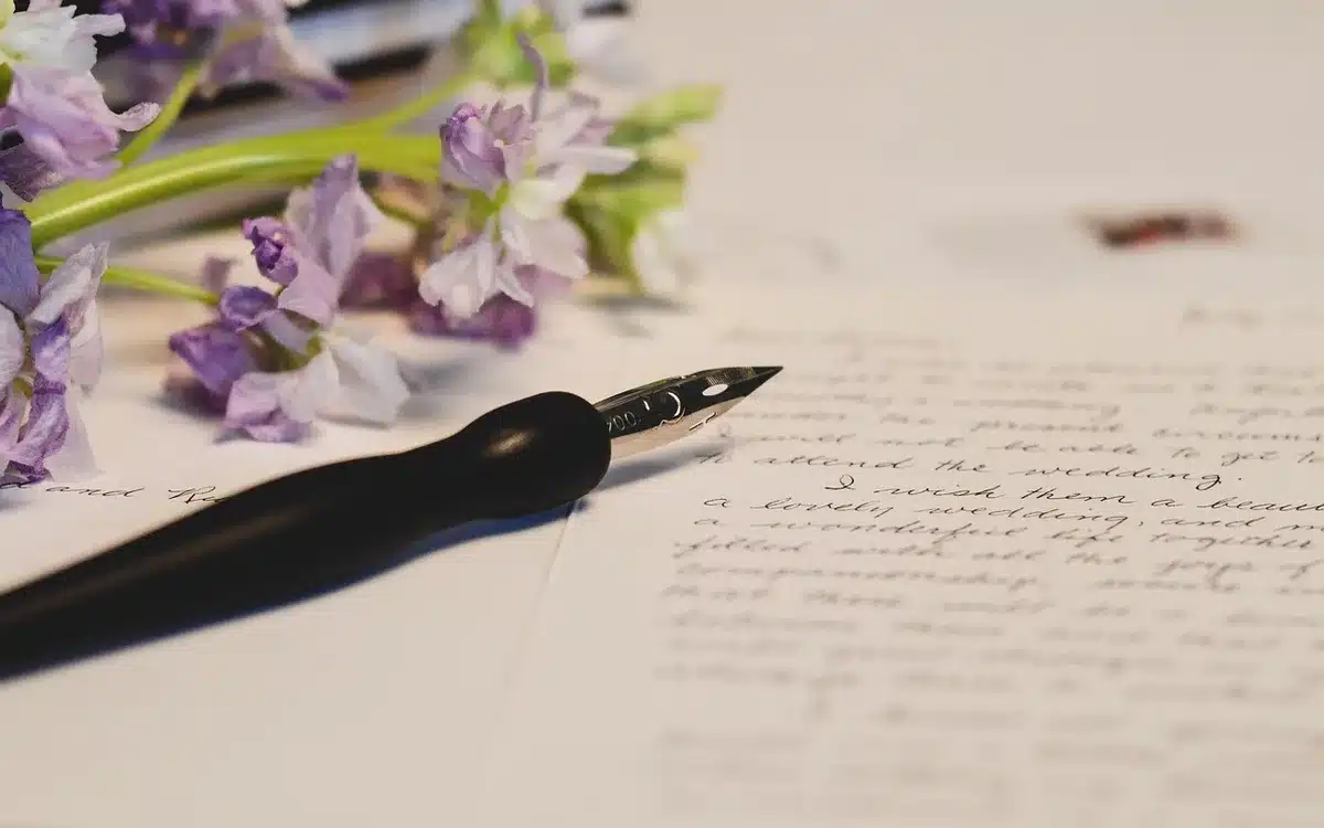 Main tenant un stylo au-dessus d'un court questionnaire sur une table en journée