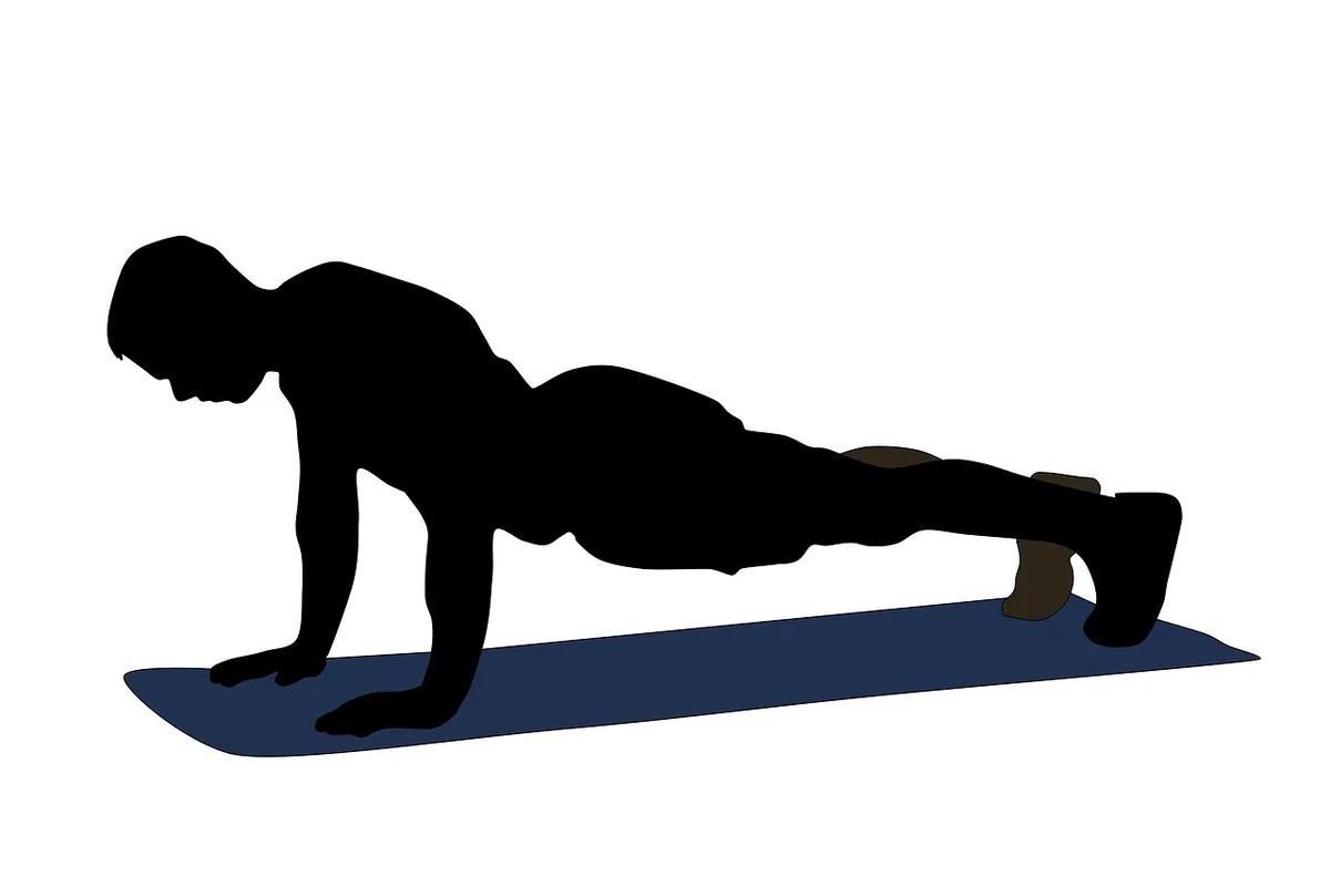 Personne tenant la planche sur un tapis de yoga à la maison