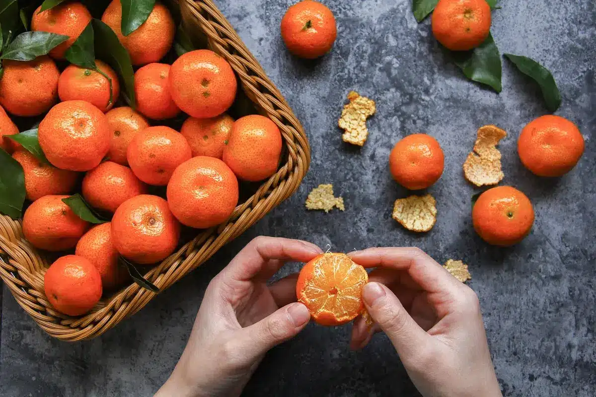 Écorces d'orange entières et coupées montrant le zeste et la pulpe