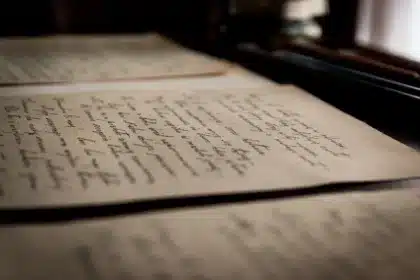 Mains sur une table avec documents et téléphone, lumière du jour dans un salon